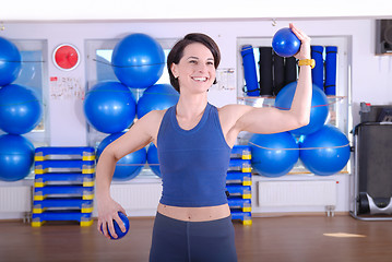 Image showing .happy young woman exercising in a gym