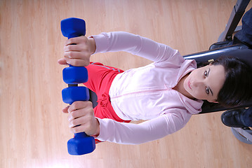 Image showing .a young woman weightlifting at gym 