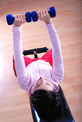 Image showing .a young woman weightlifting at gym 