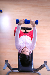 Image showing .a young woman weightlifting at gym 