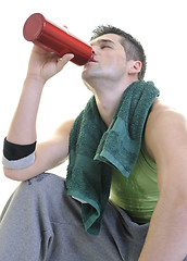 Image showing sportsman relaxing and drinking water