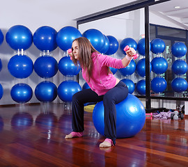 Image showing young pretty woman exercising in a fitness center