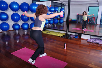 Image showing young pretty woman exercising in a fitness center