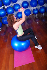 Image showing young pretty woman exercising in a fitness center