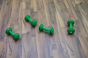 Image showing green dumbbells on patquet floor