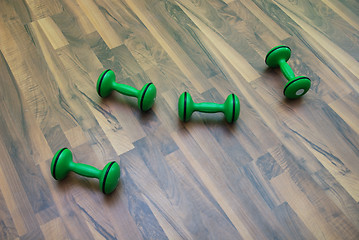 Image showing green dumbbells on patquet floor