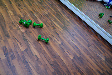 Image showing green dumbbells on patquet floor