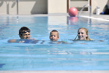 Image showing happy young family have fun on swimming pool