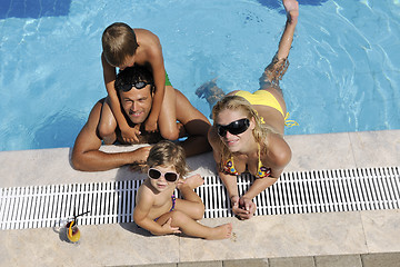 Image showing happy young family have fun on swimming pool