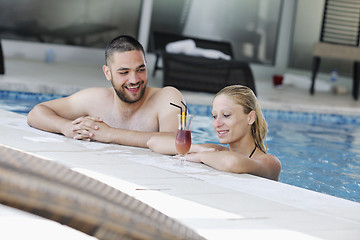 Image showing happy cople relaxing  at swimming pool