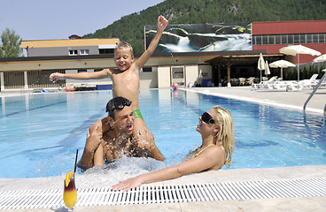 Image showing happy young family have fun on swimming pool