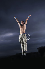 Image showing young man dancing and jumping  on top of the building 