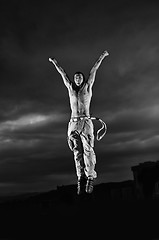 Image showing young man dancing and jumping  on top of the building 