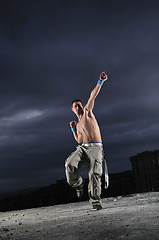 Image showing young man dancing and jumping  on top of the building 