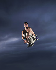 Image showing young man dancing and jumping  on top of the building 