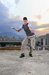 Image showing young man jumping in air outdoor at night ready to party