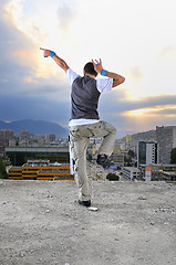 Image showing young man jumping in air outdoor at night ready to party