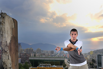 Image showing young man jumping in air outdoor at night ready to party