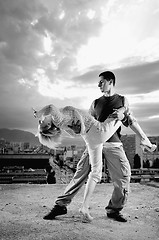 Image showing romantic urban couple dancing on top of  bulding