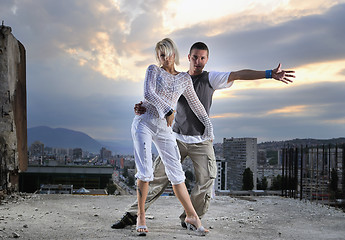 Image showing romantic urban couple dancing on top of  bulding