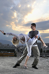 Image showing romantic urban couple dancing on top of the bulding 