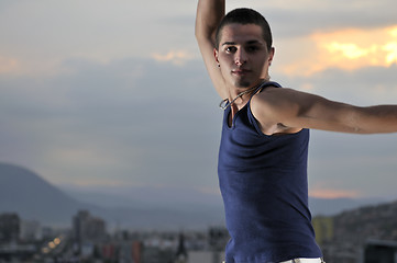 Image showing young man jumping in air outdoor at night ready for party