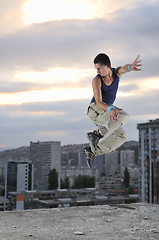 Image showing young man jumping in air outdoor at night ready for party