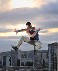 Image showing young man jumping in air outdoor at night ready for party