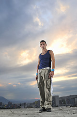 Image showing young man dancing and jumping  on top of the building 