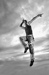 Image showing young man dancing and jumping  on top of the building 