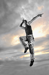 Image showing young man dancing and jumping  on top of the building 