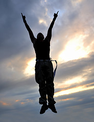 Image showing young man jumping in air outdoor at night ready for party