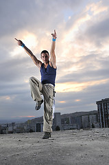 Image showing young man dancing and jumping  on top of the building 