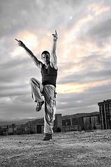 Image showing young man dancing and jumping  on top of the building 