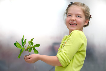 Image showing little girl holding small plant