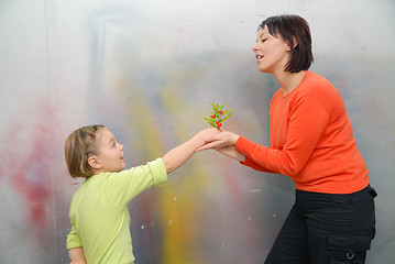 Image showing Girl giving mother flowers