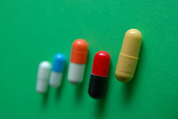 Image showing pills on green background in row