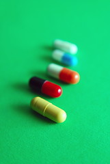 Image showing pills on green background in row