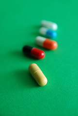 Image showing pills on green background in row