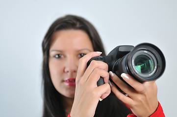 Image showing Young woman holding camera in hand taking picture isolated