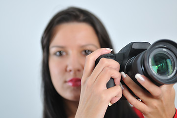 Image showing Young woman holding camera in hand taking picture isolated