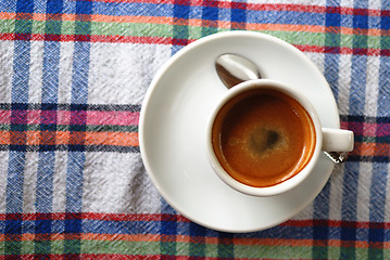 Image showing Cup of coffee on a colorful tablecloth