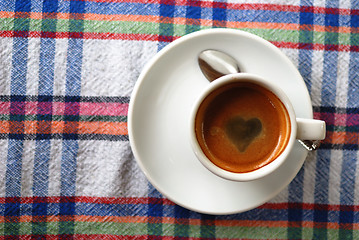 Image showing Cup of coffee on a colorful tablecloth