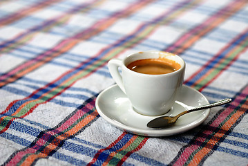 Image showing Cup of coffee on a colorful tablecloth