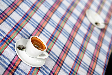 Image showing Cup of coffee on a colorful tablecloth