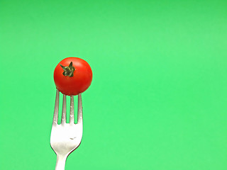 Image showing fresh tomato on fork with green background