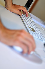 Image showing lose-up of male hand on mouse while working on laptop