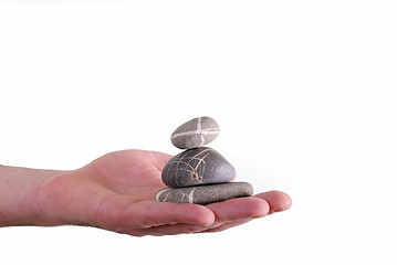 Image showing Man holding balanced zen rocks