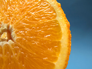 Image showing sliced orange macro with blue background