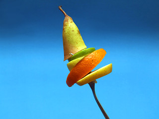 Image showing sliced fruits on fork